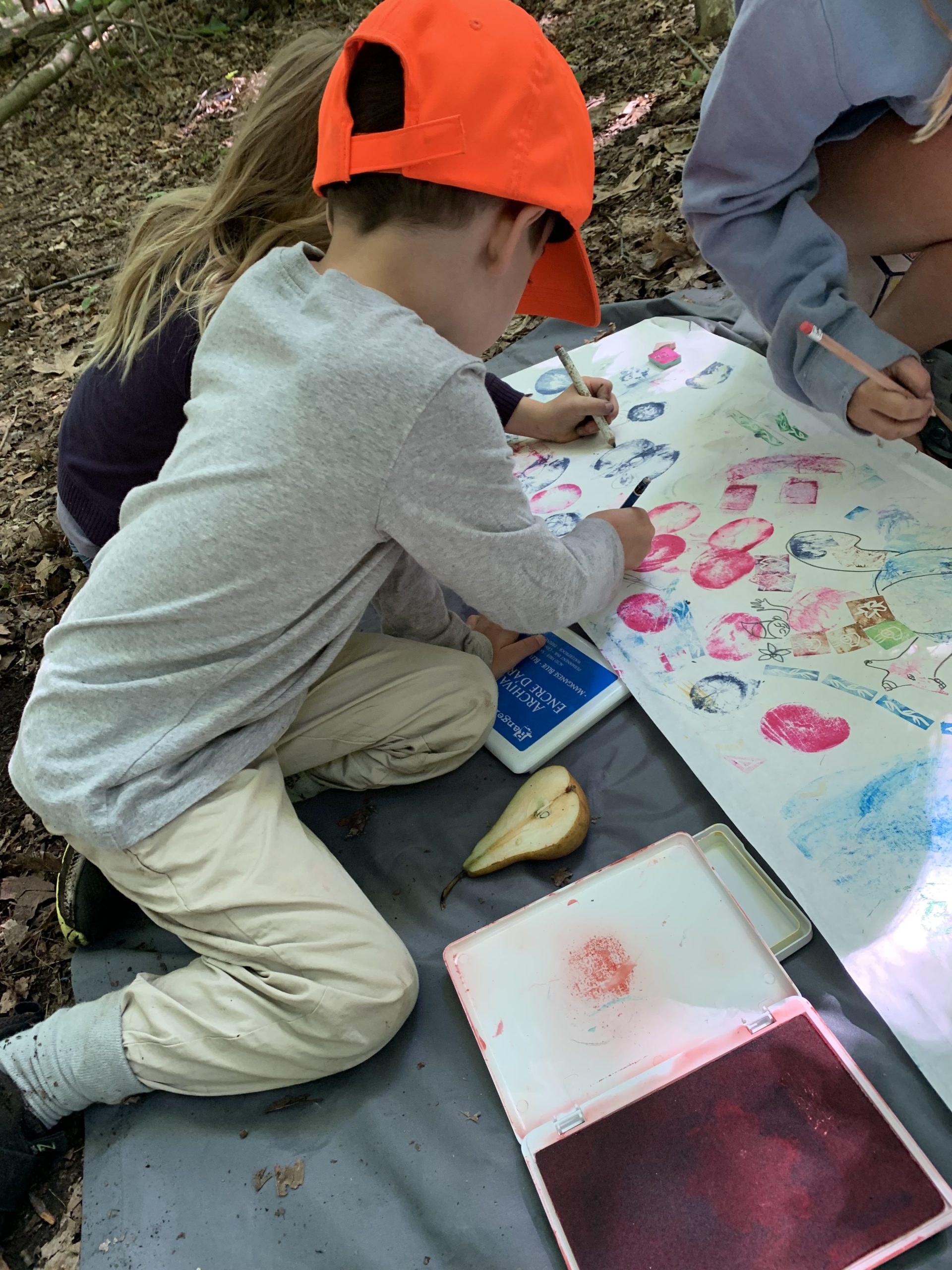 Kids creating a collage with stamps at Ann Arbor summer art camp